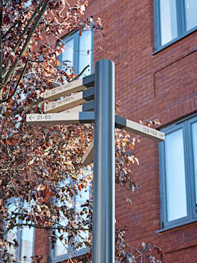 A signpost with arrows pointing left and right with the left arrow pointing to "ST THE GREEN" and the right arrow pointing to "21-65".