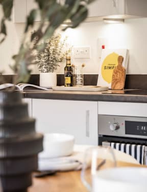 A kitchen counter with a Simply branded container and a plant on it at The Foundry Apartments, Bordon