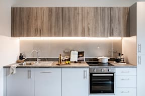 A modern kitchen with a stove, sink, and cabinets.