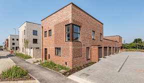 A long brick building with a large window on the side at Origins Apartments, Cambridge