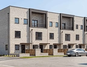 A modern apartment building with a car parked in front at Origins Apartments, Cambridge, CB3 0UX