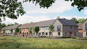 A row of houses with a field of flowers in front at The Foundry Apartments, Bordon