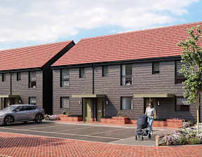 A woman pushing a stroller walks in front of a building with a grey car parked in front at The Woodlands Apartments, Milton Keynes