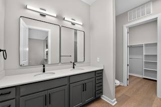 A bathroom with two sinks and a large mirror.