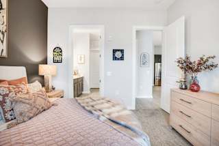 A bedroom with a bed, dresser, and mirror.