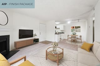 A living room with a fireplace and a TV on the wall