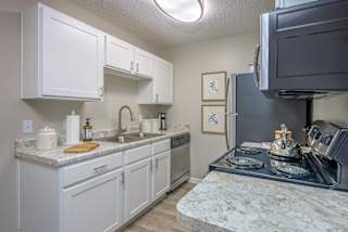 a kitchen with white cabinets and granite countertops  at St. Andrews Reserve, North Carolina, 28412