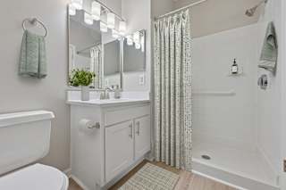 A white bathroom with a white tub and a white toilet.