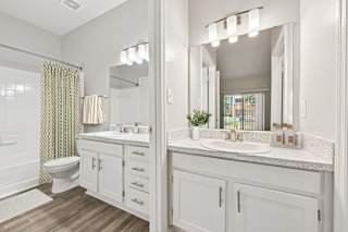 A bathroom with a toilet, sink, and mirror.
