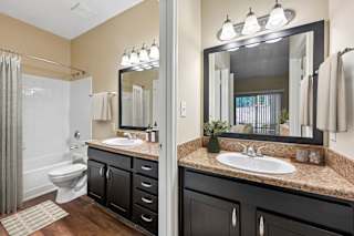 A bathroom with a sink, mirror, and toilet.