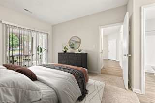 A bedroom with a bed, a dresser, and a mirror.