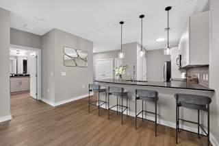 A kitchen with a bar area and a framed artwork on the wall.