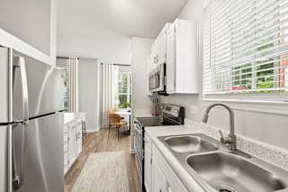 A modern kitchen with a stainless steel refrigerator and a granite countertop.