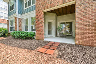 A brick house with a white door and a small garden in front.