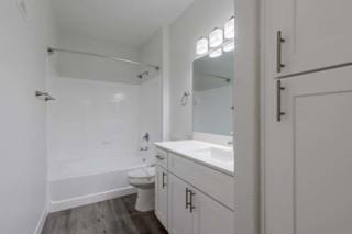 A white bathroom with a toilet, sink, and tub.