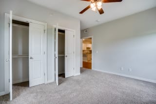Carpeted Bedroom With Dual Closets & Ceiling Fan