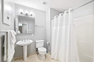 a bathroom with a white shower curtain and a white toilet