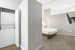 a bedroom with a bed and a washer and dryer