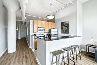 a kitchen with a breakfast bar and stools in a 555 waverly unit