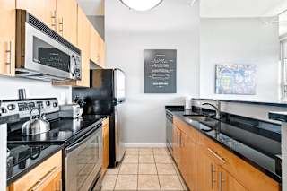 a kitchen with black countertops and wooden cabinets