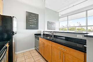 a kitchen with black countertops and a large window