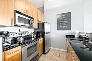 a kitchen with black countertops and stainless steel appliances