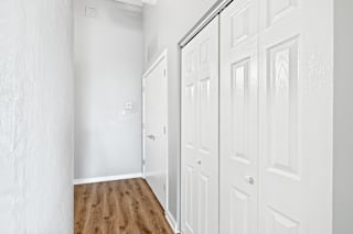 a bedroom with two closets and hardwood floors