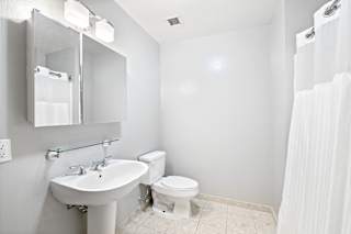 a bathroom with a sink toilet and mirror