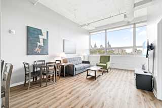 a living and dining area with hardwood floors and a large window