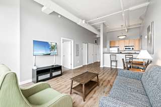 a living room with a couch a chair a coffee table and a flat screen tv
