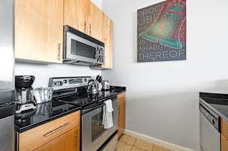 a kitchen with a stove top oven next to a sink and a microwave