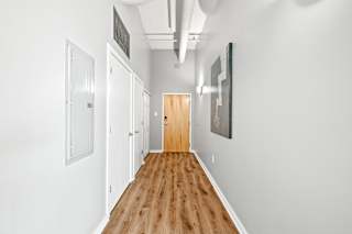a long hallway with white walls and wood floors