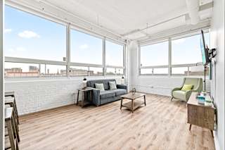 a living room with hardwood floors and large windows