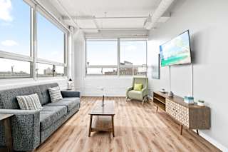 a living room with wood floors and large windows