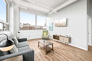 a living room with a large window and hardwood floors