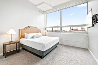 a bedroom with a bed and a large window