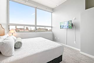 a bedroom with a large window and a large bed