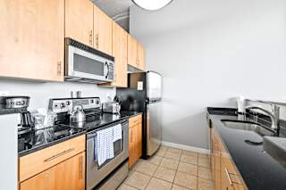 a kitchen with wood cabinets and black countertops