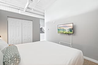 a bedroom with a large bed and a flat screen tv
