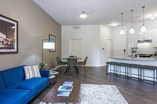 a living room with a blue couch and a table with chairs