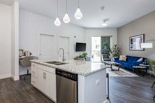 a kitchen with an island and a living room with a couch and a television