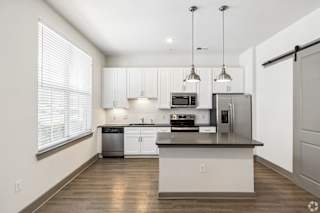 A modern kitchen with white cabinets and stainless steel appliances.