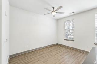 A room with a ceiling fan and a window with blinds.