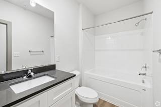 A white bathroom with a sink, toilet, and bathtub.