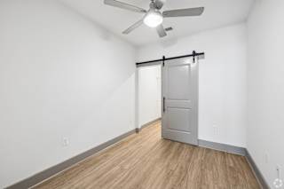 A room with a sliding door and a ceiling fan.