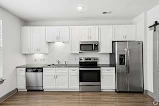 A modern kitchen with white cabinets and stainless steel appliances.