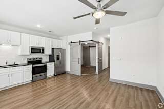 A kitchen with white cabinets and a wooden floor.