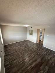 A room with wooden flooring and white walls.