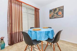 A dining table with a blue tablecloth and two plates on it.