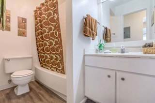 A white toilet sits next to a white sink in a bathroom.